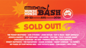 Festival poster for Broken Hill Bash Mund Mundi, Aug 20–22, 2026, Sold Out, with the band lineup listed at the bottom in white text on a pink/orange background.
